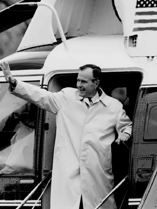 Foto file 19 November 1992, Presiden AS George Bush melambaikan tangan saat menaiki Marine One untuk berakhir pekan di retret kepresidenan di Camp David, Maryland. Bush Senior meninggal dunia pada Jumat waktu setempat di usia 94 tahun. (Luke FRAZZA / AFP)