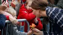 Kate Middleton menerima bunga yang diberikan oleh seorang gadis kecil setelah mengunjungi Meseum Nasional Sepak Bola di Manchester, Inggris (14/10). Kate tampil cantik didampingi suaminya Pangeran Wiliam. (Reuters/Phil Noble)