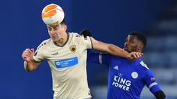 Bek AEK Athens, Ionut Nedelcearu (kiri), berduel udara dengan striker Leicester City, Kelechi Iheanacho, dalam laga lanjutan Liga Europa 2020/21 Grup G di King Power Stadium, Kamis (10/12/2020). AEK Athens kalah 0-2 dari Leicester City. (AFP/Ben Stansall)