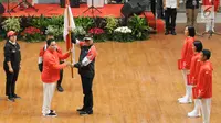 Ketua KOI, Erick Thohir (kedua kiri) menyerahkan bendera Merah Putih kepada Ketua Kontingen Indonesia untuk Asian Games 2018, Komjen Pol Syafruddin saat upacara pengukuhan di Istora Senayan, Jakarta, Minggu (5/8). (Liputan6.com/Helmi Fithriansyah)