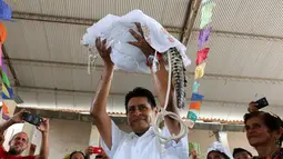 Wali Kota San Pedro Huamelula, Joel Vasque mengangkat sang mempelai wanita, yaitu seekor buaya saat akan menjalani ritual pernikahan di Oaxaca, Meksiko, 30 Juni 2015. (AFP PHOTO/MARIO JIMENEZ) 