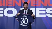 Pemain baru Paris Saint-Germain (PSG), Lionel Messi memegang kaus nomor 30 miliknya setelah pers konferensi di stadion Parc des Princes di Paris, Rabu (11/8/2021). Messi dikontrak oleh PSG selama dua tahun dengan opsi perpanjangan setahun di klub kaya Paris itu. (AP Photo/Francois Mori)