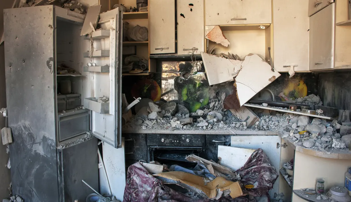 Puing-puing menutupi dapur yang rusak di sebuah gedung apartemen yang terkena tembakan di Kharkiv, Ukraina, 20 Maret 2022. Pada Hari 25 perang Rusia di Ukraina, kehidupan yang kacau, perpisahan yang pahit tertangkap dalam foto-foto Associated Press. (AP Photo/Andrew Marienko)