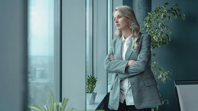 Wanita melihat pemandangan di luar kantor