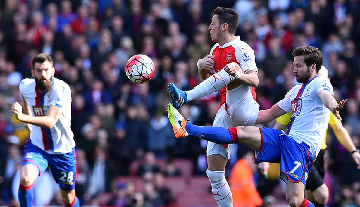 Gelandang Arsenal, Mesut Ozil, berebut bola dengan gelandang Crystal Palace, Yohan Cabaye, pada laga Liga Premier Inggris di Stadion Emirates, London, Minggu (17/4/2016). Kedua tim bermain imbang 1-1. (AFP/Ben Stansall)