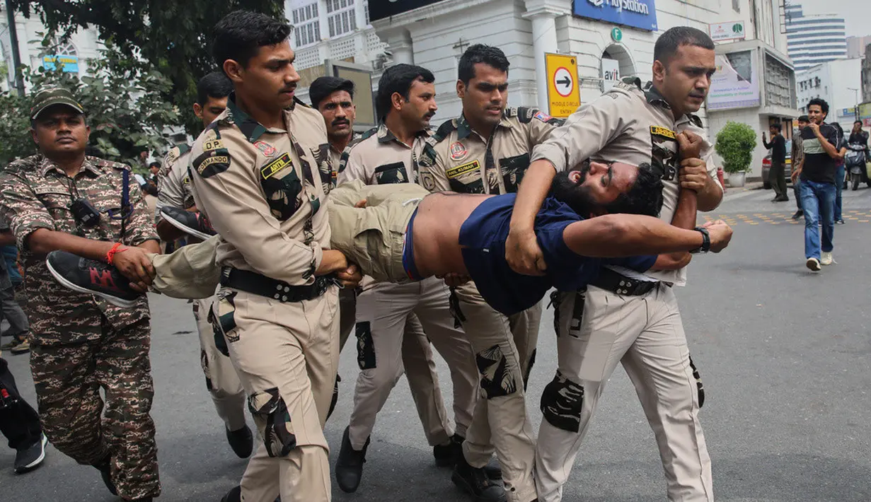 Petugas kepolisian menahan seorang demonstran saat aksi unjuk rasa yang menuntut pengunduran diri Ketua Komisi Pemilihan Umum India, Gyanesh Kumar, di New Delhi, India, Minggu (11/10/2026). (AP Photo/Prabhat Mehrota)