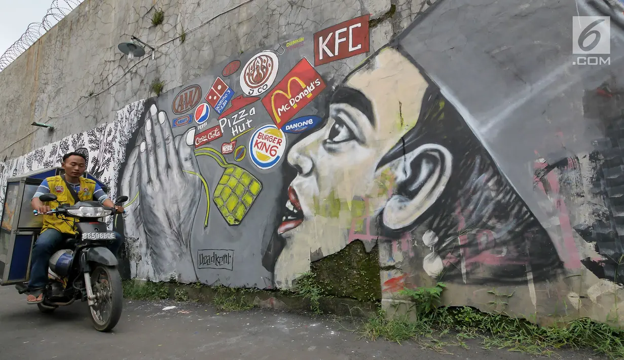 Pengendara sepeda motor melintas di depan dinding berhias mural bertema Islami di Gang Abdul Jabar, Jagakarsa, Jakarta, Senin (28/5). (Liputan6.com/Herman Zakharia)