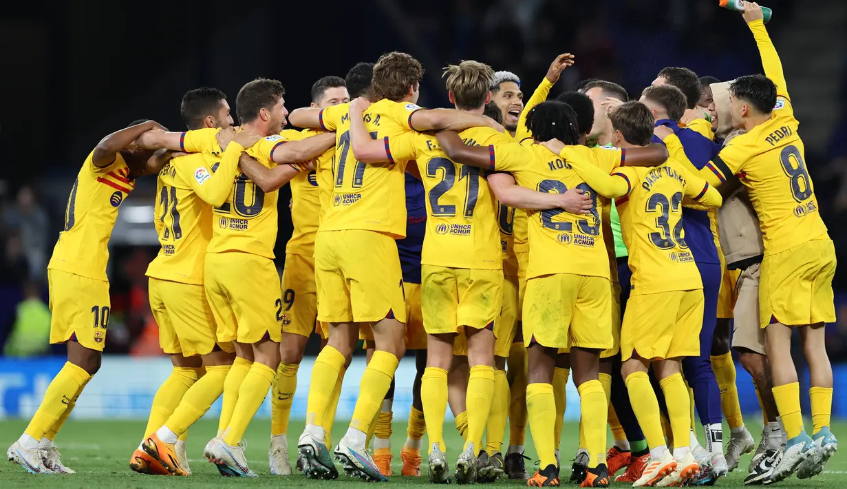 Tim asuhan Xavi Hernandez menari dan bernyanyi untuk merayakan kesuksesan mereka. (Photo by Lluis GENE / AFP)
