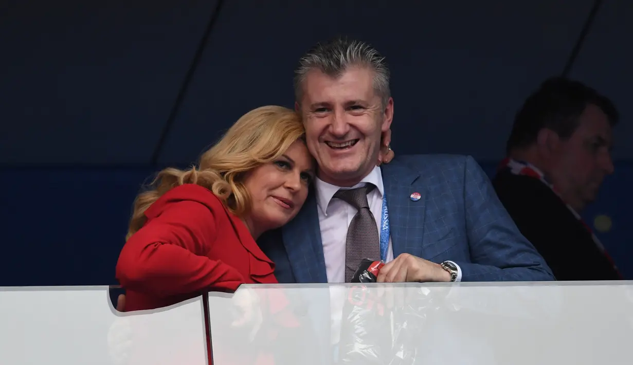 Kolinda Grabar-Kitarovic (kiri) bersama mantan pemain Kroasia, Davor Suker pada final Piala Dunia 2018 di Luzhniki Stadium, Moskow, Rusia, (15/7/2018). Meski Kroasia kalah Kolinda Grabar-Kitarovic tetap tersenyum manis. (AFP/Kirill Kudryavtsev)