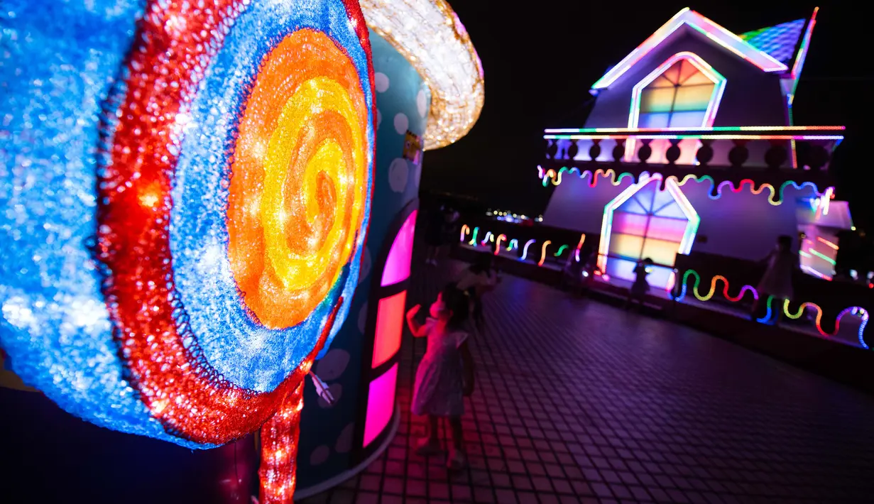 Orang-orang menikmati pemandangan malam di Festival Cahaya Makau 2020 yang digelar di Tap Seac Square, Makau, China selatan, pada 26 September 2020. Festival cahaya tersebut dimulai pada Sabtu (26/9) dan akan berlangsung hingga 31 Oktober. (Xinhua/Cheong Kam Ka)