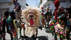 Sejumlah orang menari sambil mengenakan kostum dan topeng saat perayaan tradisional di Naiguata, Venezuela (31/5). Sejumlah orang kerasukan dan menari selama festival yang dikenal Dancing Devils ini di Naiguata. (AP/Arian Cubillos)