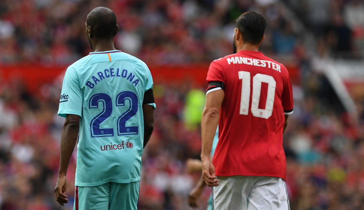 Legenda Barcelona, Eric Abidal dan legenda Manchester United, Ruud van Nistelrooy saat laga persahabatan di Stadion Old Trafford, Sabtu (2/9/2017). Pertandingan tersebut merupakan laga amal. (AFP/Paul Ellis)