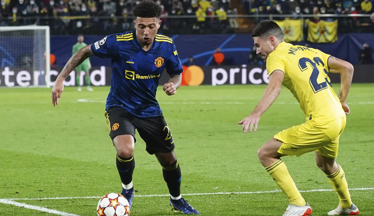 Penyerang Manchester United (MU) Jadon Sancho berebut bola dengan gelandang Villarreal Moi Gomez pada matchday kelima Grup F Liga Champions di Ceramica stadium, Rabu (24/11/2021) dini hari WIB. MU sukses meraih kemenangan 2-0 di kandang Villarreal. (AP Photo/Alberto Saiz)