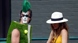 Penonton mengenakan kostum lapangan tenis tiba untuk mengambil tempat duduk selama turnamen tenis Wimbledon 2019 hari ke tujuh di The All England Tennis Club, London (2/7/2019). (AP Photo/Alastair Grant)