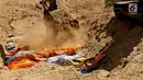 Puluhan jenazah dikubur massal menggunakan eskavator di TPU Peboya Indah, Palu, Sulawesi Tengah, Rabu (3/10). Jenazah yang merupakan korban gempa tsunami dikubur tiga lapis. (Liputan6.com/Fery Pradolo)