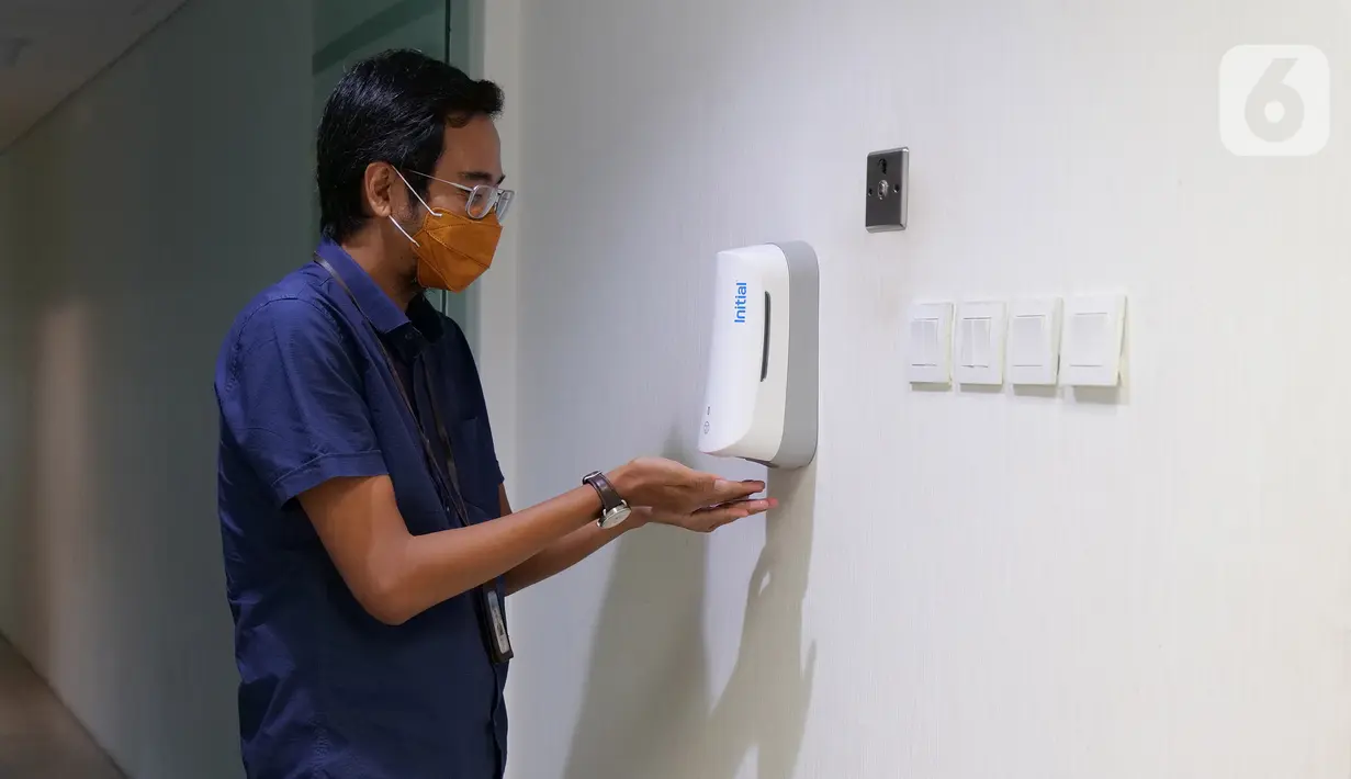 Karyawan menggunakan hand sanitizer atau cairan pembersih tangan saat memasuki ruang kerja di Suntory Garuda, Jakarta, Senin (8/8/2020). Perusahaan itu menerapkan protokol kesehatan saat hari pertama kerja di masa PSBB transisi yang diterapkan oleh Pemprov DKI Jakarta. (Liputan6.com/Herman Zakharia)