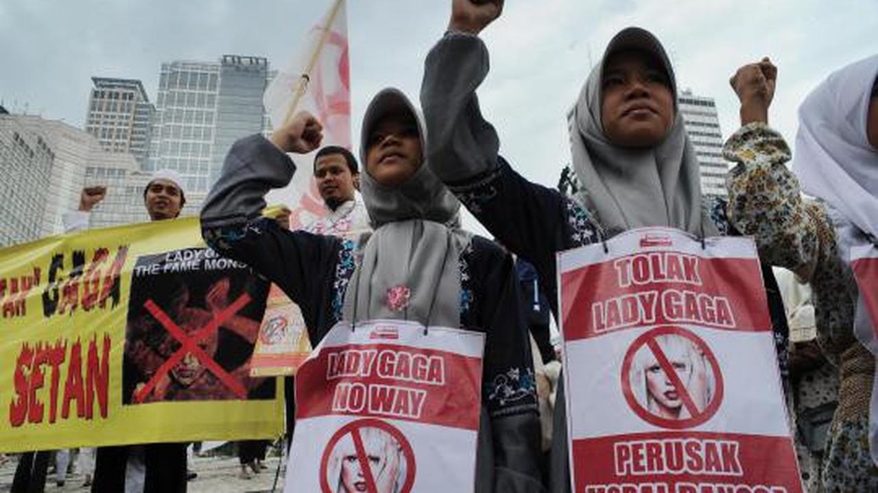 Seorang demonstran membawa poster penolakan konser Lady Gaga pada aksi 