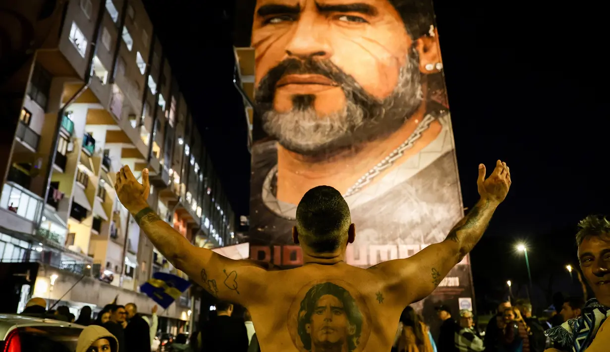 Fans merayakan ulang tahun Diego Maradona di bawah mural legenda sepak bola itu di Distrik San Giovanni, Napoli, Italia, 30 Oktober 2022. Legenda sepak bola asal Argentina, Diego Armando Maradona yang lahir pada 30 Oktober 1960 meninggal pada 25 November 2020. (Alessandro Garofalo/LaPresse via AP)