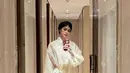 Renata Kusmanto kenakan busana off white yang iapdukan atasan berjaring dengan pleated skirt midi metalik. Ia kenakan sling bag dari Simona Rocha yang ikonik [@renata711]