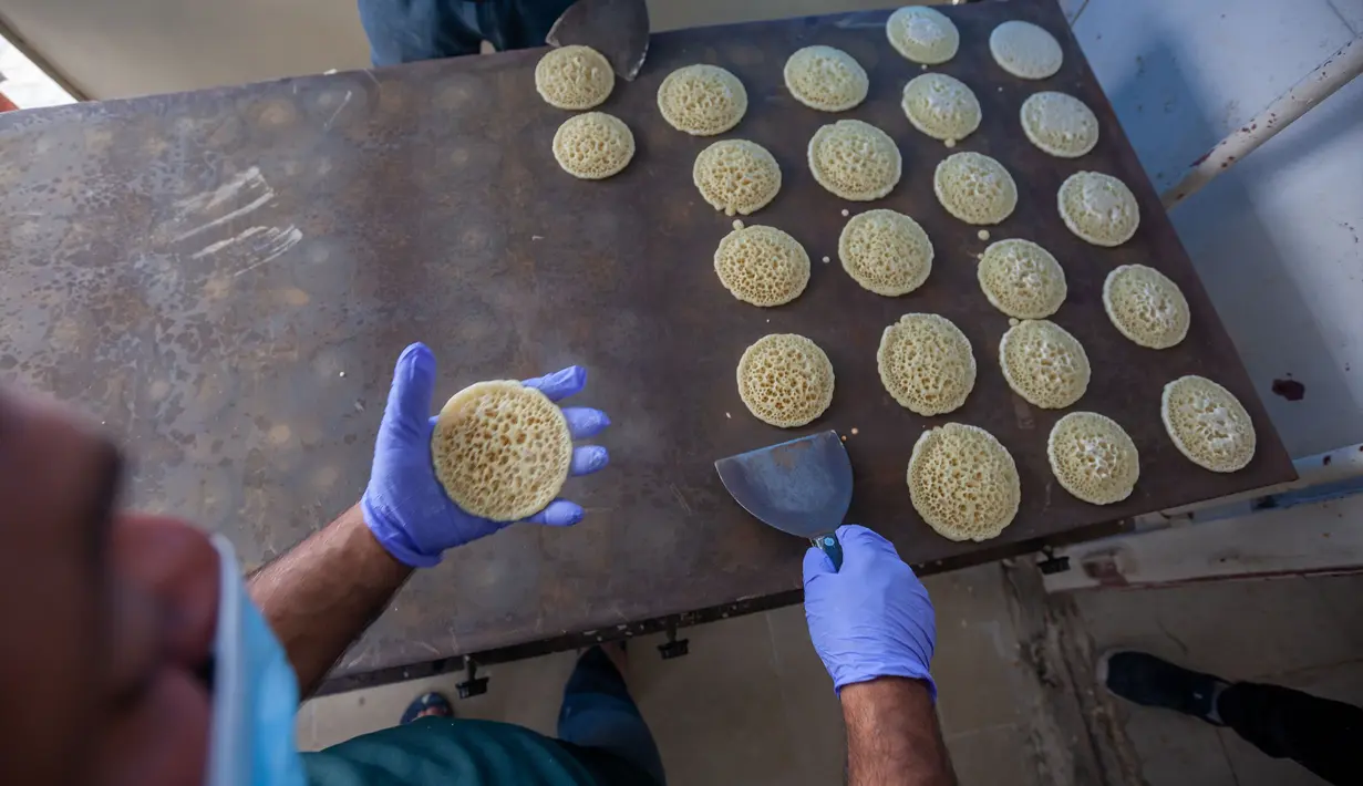 Warga Palestina membuat kue tradisional yang disebut Qatayef, salah satu hidangan penutup khas bulan suci Ramadan di Kota Betlehem, Tepi Barat, Sabtu (25/4/2020). (Xinhua/Luay Sababa)