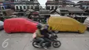 Pengendara motor melintas di jalur inspeksi Kanal Banjir Barat, Jakarta, Senin (6/3). Keterbatasan lahan menyebabkan sejumlah kendaraan parkir di tempat tersebut, meskipun telah terpampang larangan parkir. (Liputan6.com/Immanuel Antonius)