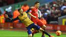 Pemain Liverpool, James Milner (kanan)  berebut bola dengan pemain  Arsenal, Aaron Ramsey (kiri) pada lanjutan Liga Premier Inggris di Stadion Anfield, Liverpool, Kamis (13/1/2016) dini hari.  (EPA/Peter Powell)