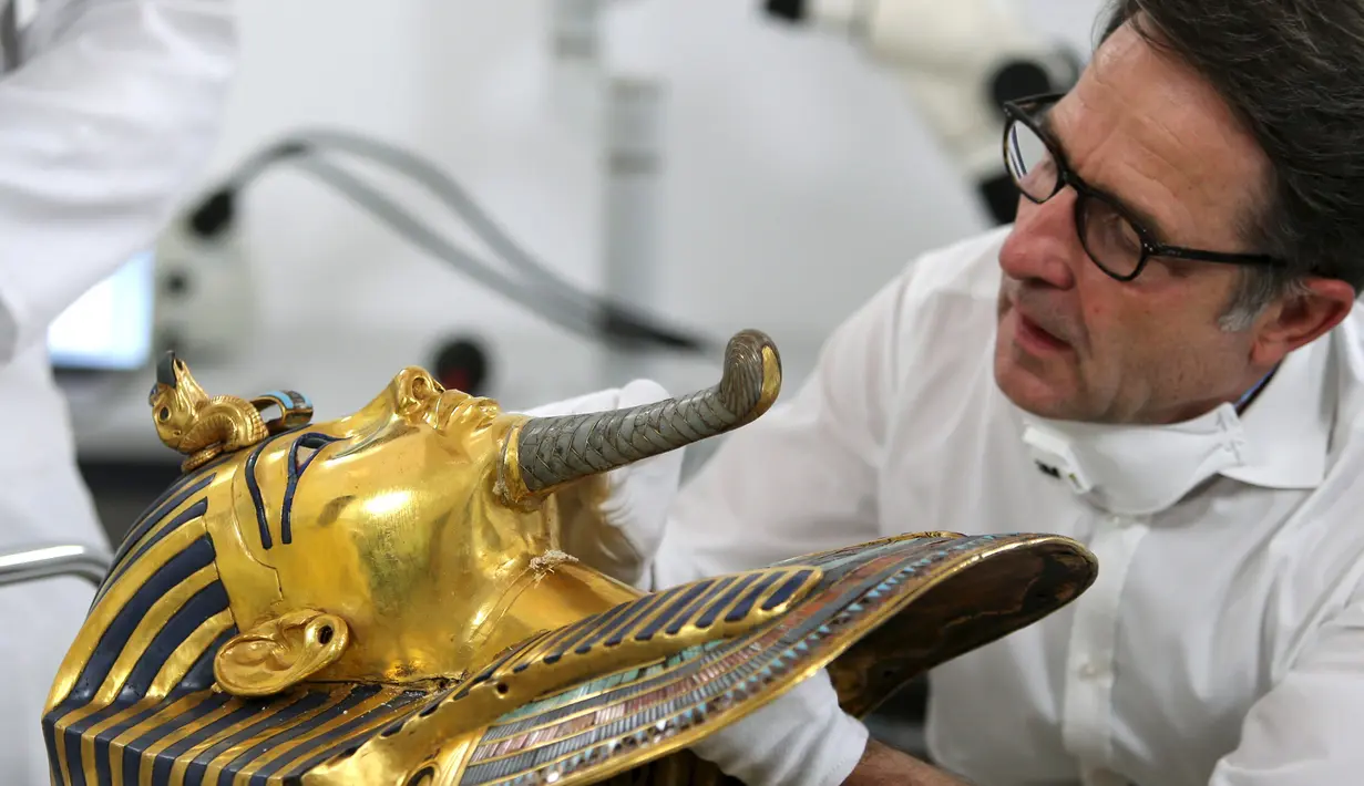 Christian Eckmann, kolektor benda bersejarah asal Jerman melihat kondisi topeng emas Raja Tutankhamun di museum Mesir, Kairo, Selasa (20/10/2015). Topeng emas Tutankhamun terdiri dari 11 kg emas murni. (REUTERS/Mohamed Abd El Ghany)
