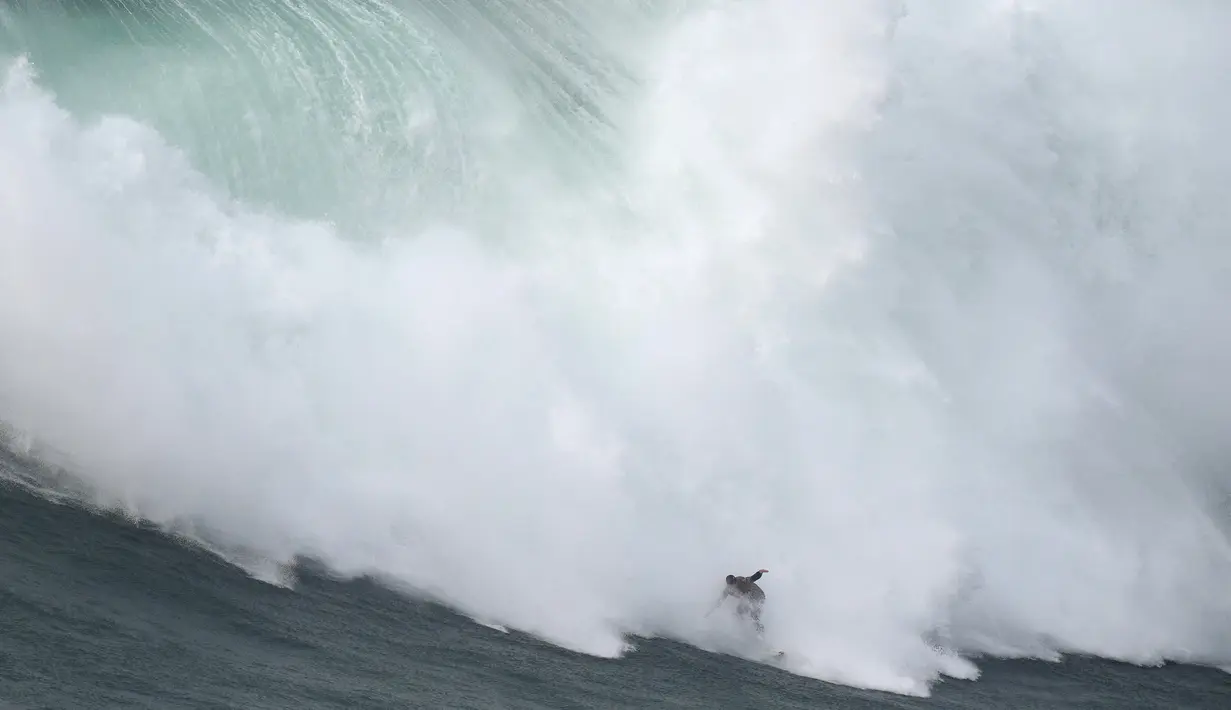 Peselancar Nic von Rupp dari Portugal mengendarai ombak selama kompetisi selancar ombak besar Nazare Tow Challenge di Praia do Norte, atau Pantai Utara, di Nazare, Portugal, Kamis, 10 Februari 2022. (AP Photo/Armando Franca)