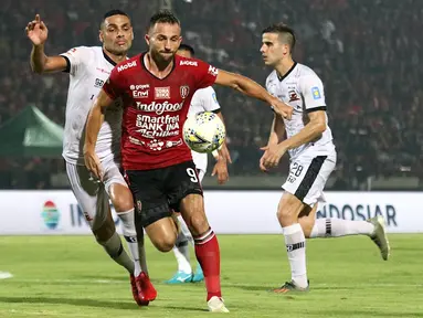 Striker Bali United, Ilija Spasojevic, berebut bola dengan bek Madura United, Jaimerson Xavier, pada laga Liga 1 2019 di Stadion Kapten I Wayan Dipta, Bali, Minggu (22/12). Bali kalah 0-2 dari Madura. (Bola.com/Aditya Wany)