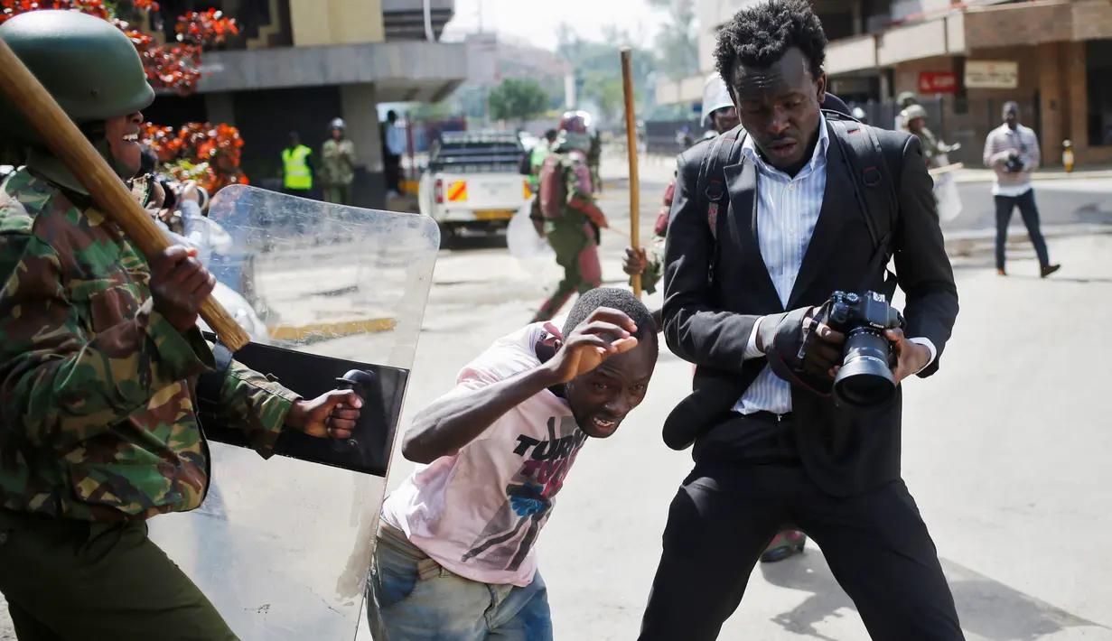 Seorang jurnalis foto berusaha mengabadikan gambar saat bentrokan di Nairobi, Kenya (16/5). Demonstran menuntut pembubaran otoritas pemilu karena adanya dugaan korupsi. (REUTERS/Goran (REUTERS/Goran Tomasevic)