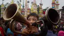 Seorang anak meniup trompet untuk menandai mulainya Festival Behdienkhlam di desa Tuber, India (24/7). Festival Behdienkhlam  adalah salah satu festival paling populer di kawasan Meghalaya. (AP Photo/Anupam Nath)