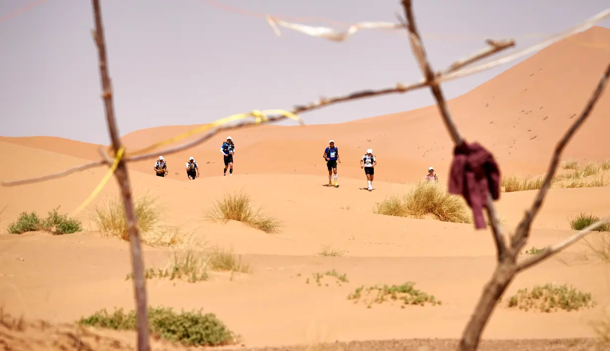 Para Peserta mendaki gurun Sahara saat mengambil bagian dalam kejuaraan marathon des Sables di Maroko Selatan, (10/4). Peserta akan menempuh jarak sekitar 257 kilometer melintasi panasnya gurun Sahara. (AFP PHOTO/JEAN-PHILIPPE Ksiazek)