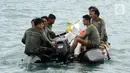 Tim SAR gabungan membawa serpihan pesawat Sriwijaya Air SJ 182 dengan perahu karet di perairan Kepulauan Seribu, Jakarta, Minggu (10/1/20221). Sriwijaya Air SJ 182 hilang kontak empat menit usai lepas landas dari Bandara Soetta. (merdeka.com/Arie Basuki)