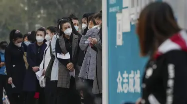 Wanita yang memakai masker wajah mengantre untuk mendapatkan tes usap tenggorokan COVID-19 rutin mereka di tempat pengujian virus corona di Beijing, Rabu (26/10/2022). Kota Shanghai di China mulai memberikan vaksin COVID-19 yang dapat dihirup pada hari Rabu di tempat yang tampaknya menjadi yang pertama di dunia. (AP/Andy Wong)