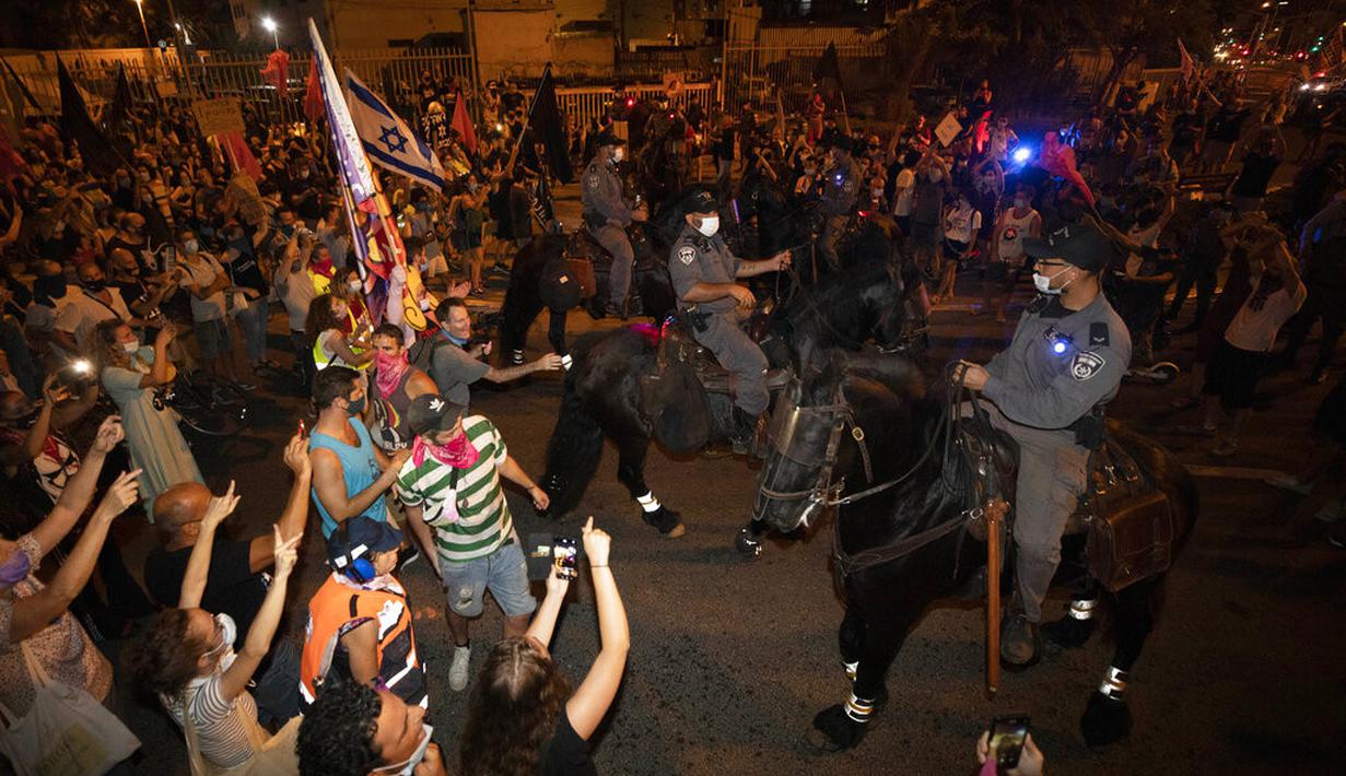 Polisi menahan seorang pengunjuk rasa selama demonstrasi menentang tindakan lockdown di Tel Aviv, Israel, Kamis (1/10/2020). Pengunjuk rasa meyakini lockdown ditujukan untuk mengekang protes terhadap Perdana Menteri Israel Benjamin Netanyahu. (AP Photo/Sebastian Scheiner)