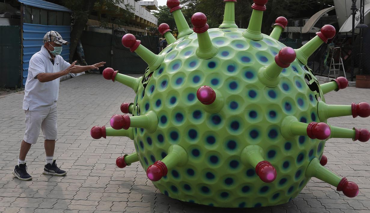 Desainer mobil India K. Sudhakar Yadav berdiri di samping mobil bertema Coronavirus di museum yang ia buat sebagai bagian dari kampanye kesadaran yang bertujuan mencegah penyebaran virus di Hyderabad, India, Selasa (7/4/2020). (AP Photo/Mahesh Kumar A.)