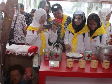 Pengunjung mengamati barang koleksi PMI yang dipamerkan dalam rangka peringatan HUT ke-70 PMI di Museum Nasional, Jakarta, Kamis (10/9). Merayakan hari jadinya, PMI menggelar pameran dan peluncuran prangko. (Liputan6.com/Angga Yuniar)
