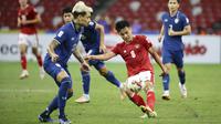 Gelandang Timnas Indonesia Witan Sulaeman mengontrol bola melawan bek Timnas Thailand Philip Roller  dalam pertandingan Babak Final Leg 1 Piala AFF 2020 di National Stadium, Singapura, Rabu (29/12/2021). Skuat Garuda menyerah 0-4 dari Thailand (AP Photo/Suhaimi Abdullah)