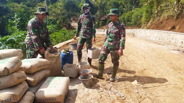 Tiga anggota TNI tengah melakukan pengadukan bahan material bangunan yang digunakan dalam pengerjaan pembangunan TPT jalan, dalam program TMMD ke 108 Makodim 0611 Garut, di Desa Wanakerta, Garut, Jawa Barat.