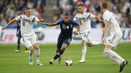 Penyerang Prancis, Kylian Mbappe, berusaha melewati pemain Jerman pada laga UEFA Nations League di Stade de France, Paris, Selasa (16/10/2018). Prancis menang 2-1 atas Jerman. (AP/Christophe Ena)