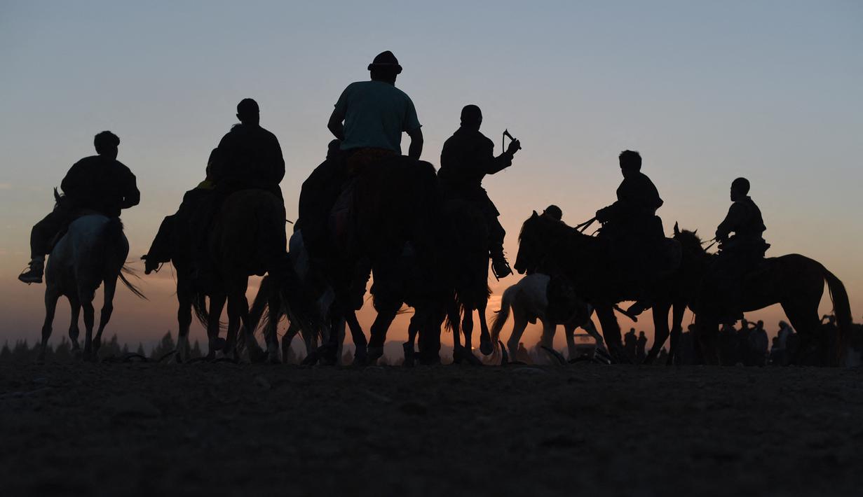 Penunggang kuda Afghanistan bersaing memperebutkan bangkai hewan dalam pertandingan Buzkashi di Herat, Afghanistan (4/2/2022). Buzkashi merupakan tradisi yang dilakukan oleh warga Afghanistan yang setiap pesertanya harus menunggang kuda. (AFP/Wakil Kohsar)