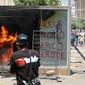 Mesin ATM bitcoin bernama Chivo terbakar selama protes terhadap kebijakan Presiden Nayib Bukele pada Hari Kemerdekaan di San Salvador, El Salvador, Rabu (15/9/2021). Ribuan warga juga memprotes Bukele yang dikhawatirkan kembali mengikuti pemilihan pada tahun 2024 mendatang. (MARVIN RECINOS/AFP)