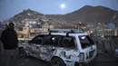 Seorang pria memeriksa kondisi mobil yang rusak usai ledakan bom di Kabul, Afganistan (28/12/2020). Sebanyak 4 orang tewas akibat ledakan yang terjadi di dua tempat terpisah tersebut. (AP Photo/Rahmat Gul)