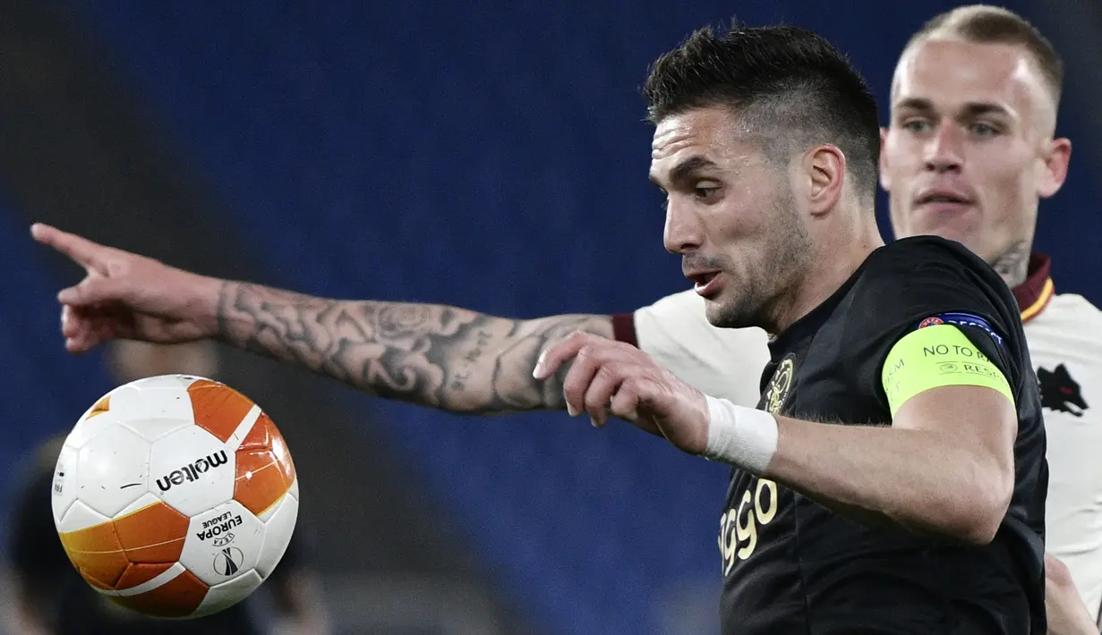 Striker Ajax Amsterdam, Dusan Tadic (kiri) mengontrol bola dibayangi bek AS Roma, Rick Karsdorp dalam laga leg kedua perempatfinal Liga Europa 2020/2021 di Olimpico Stadium, Roma, Kamis (15/4/2021). Ajax bermain imbang 1-1 dengan AS Roma. (AFP/Filippo Monteforte)