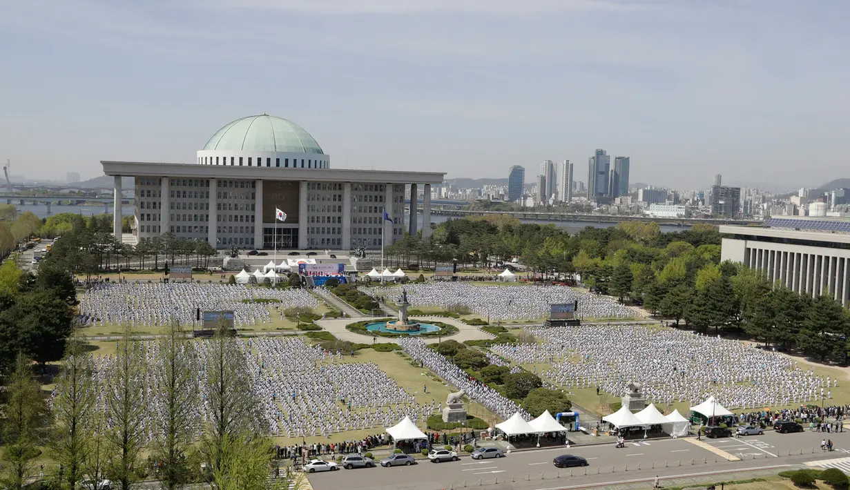 Peserta memperagakan seni bela diri taekwondo di depan Majelis Nasional Korsel, 21 April 2018. Aksi ini memperingati disahkannya taekwondo sebagai olahraga nasional setelah Majelis Nasional merevisi UU Promosi Taekwondo pada Maret lalu. (AP/Lee Jin-man)