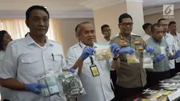 Kabid Humas Polda Metro Jaya Kombes Pol Argo Yuwono (tengah) menunjukkan barang bukti dalam rilis kasus peredaran obat tanpa izin di Polda Metro Jaya, Jakarta, Kamis (7/2). (Liputan6.com/Herman Zakharia)