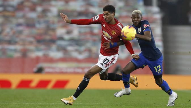 Penyerang Manchester United (MU), Marcus Rashford dan gelandang Southampton, Moussa Djenepo bersaing memperebutkan bola dalam lanjutan Liga Inggris di Old Trafford, Rabu (3/1/2021) dini hari WIB. MU memberondong gawang Southampton dengan sembilan gol tanpa balas. (Phil Noble/Pool via AP)