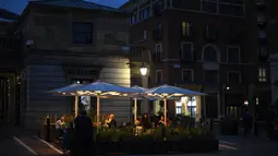 Orang-orang makan dan minum di Covent Garden, di London, Selasa (22/9/2020). Perdana Menteri Inggris, Boris Johnson, telah mengumumkan bahwa pub dan restoran tutup pada pukul 10 malam, karena lonjakan kasus virus corona di seluruh Inggris. (AP Photo / Alberto Pezzali)