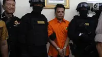 Polisi mengawal tersangka pembunuhan satu keluarga di Kota Bekasi saat gelar perkara di Polda Metro Jaya, Jakarta, Jumat (16/11). Polisi mengungkapkan tersangka HS membunuh keluarga Diperum Nainggolan seorang diri. (Merdeka.com/Imam Buhori)