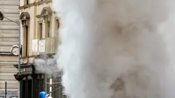 Kepulan asap putih mengepul ke udara setelah sebuah pipa uap meledak di Distrik Flatiron, Manhattan, Kamis (19/7). Tidak ada korban luka setelah ledakan pipa uap besar yang menutup jalan-jalan dan evakuasi paksa tersebut. (AP Photo/Richard Drew)